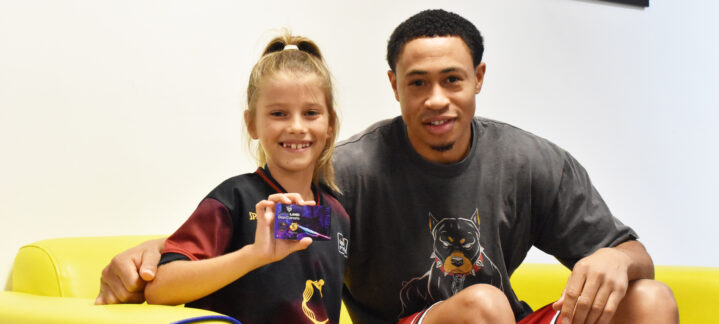 Niña sonriente con camiseta del club y jugador, sosteniendo un carné de abonado.