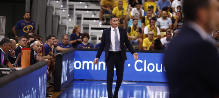 Entrenador Jaka Lakovic dirigiendo a su equipo durante un partido, con espectadores al fondo.