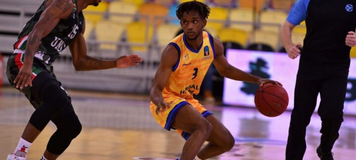 Jugador del Club Baloncesto Gran Canaria driblando mientras un rival lo defiende.