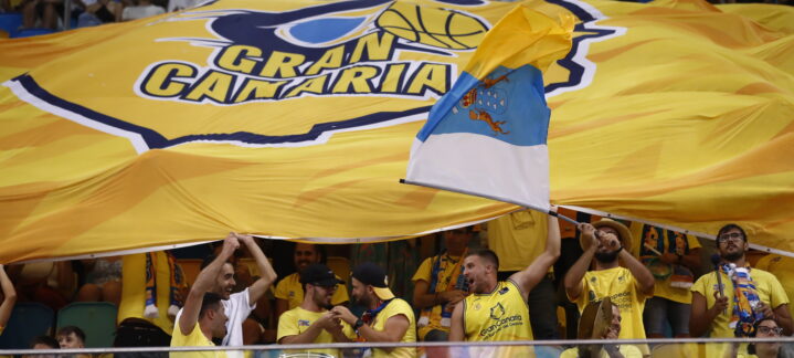 Aficionados del Club Baloncesto Gran Canaria animan con una gran bandera amarilla.