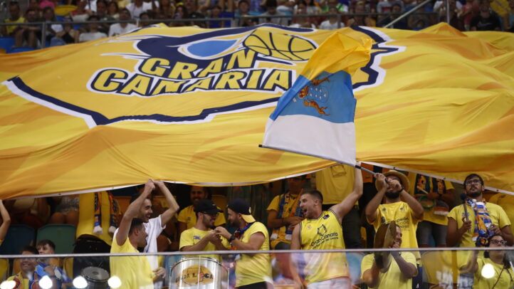 Aficionados del Club Baloncesto Gran Canaria animan con una gran bandera amarilla.
