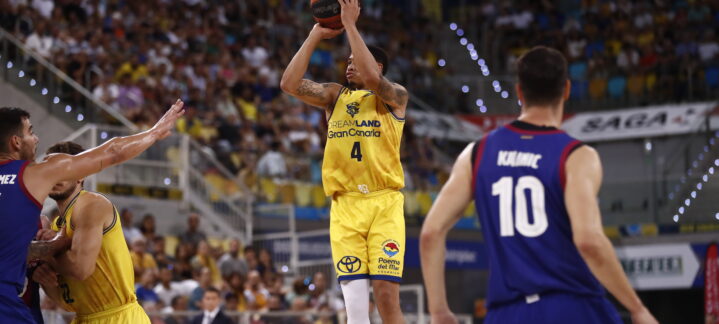es una cancha dura""",Jugador del Gran Canaria lanzando a canasta en un partido con público de fondo.