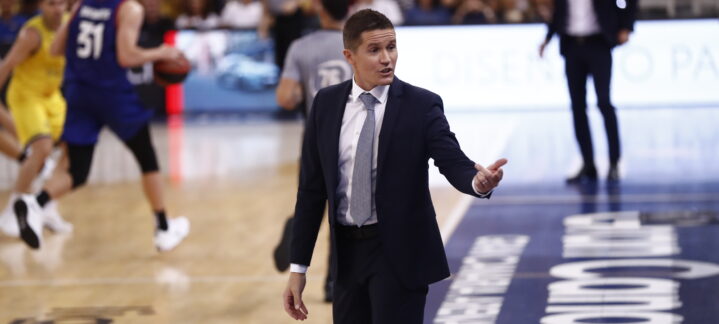 Entrenador dirigiendo al equipo durante un partido de baloncesto en la cancha.