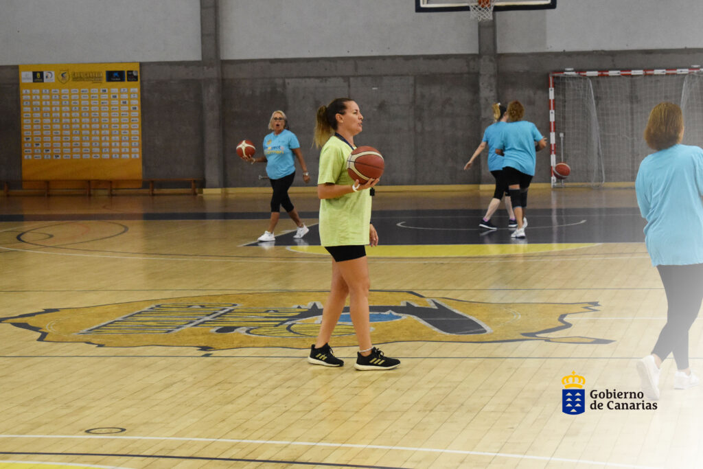 Mujeres entrenando en una cancha de baloncesto, promoviendo el Día Mundial Contra el Cáncer de Mama.