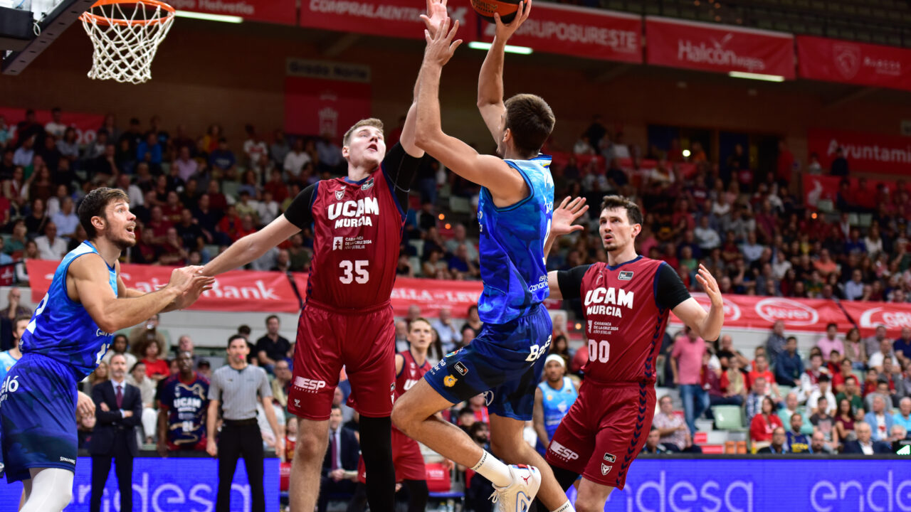 Jugador del Dreamland Gran Canaria lanza a canasta ante defensores del UCAM Murcia.