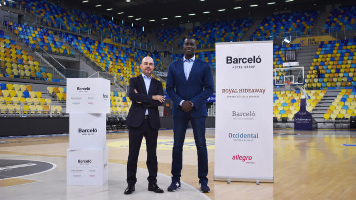 Dos representantes de Barceló Hotel Group posan en una cancha de baloncesto.