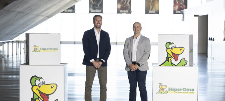 Dos hombres sonríen junto a cajas de HiperDino en un evento del Club Baloncesto Gran Canaria.