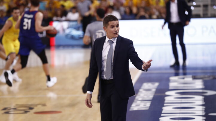 pero un ambiente muy bonito para un partido""","Entrenador dirigiendo el juego en un partido de baloncesto, con jugadores en acción.