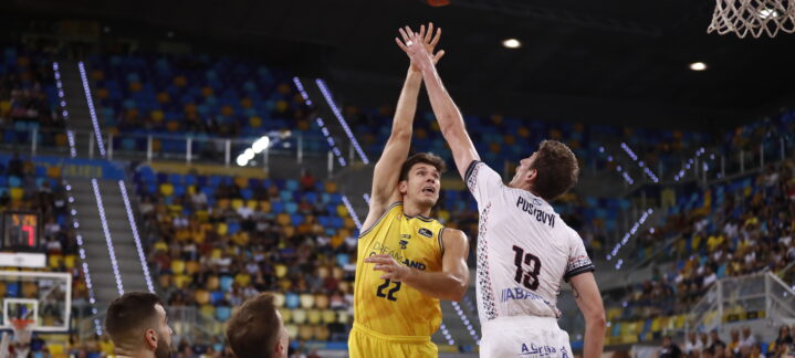 Jugador del Dreamland Gran Canaria lanza a canasta en un partido. Público de fondo.