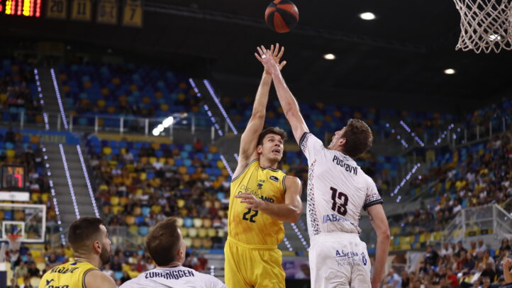 Jugador del Dreamland Gran Canaria lanza a canasta en un partido. Público de fondo.