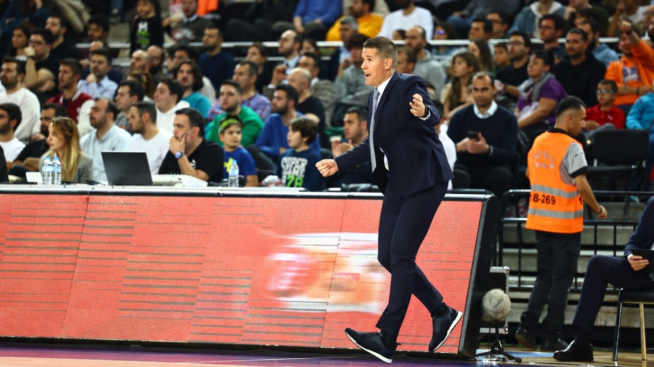 Entrenador Jaka Lakovic dirigiendo al equipo durante un partido, con gran concentración.
