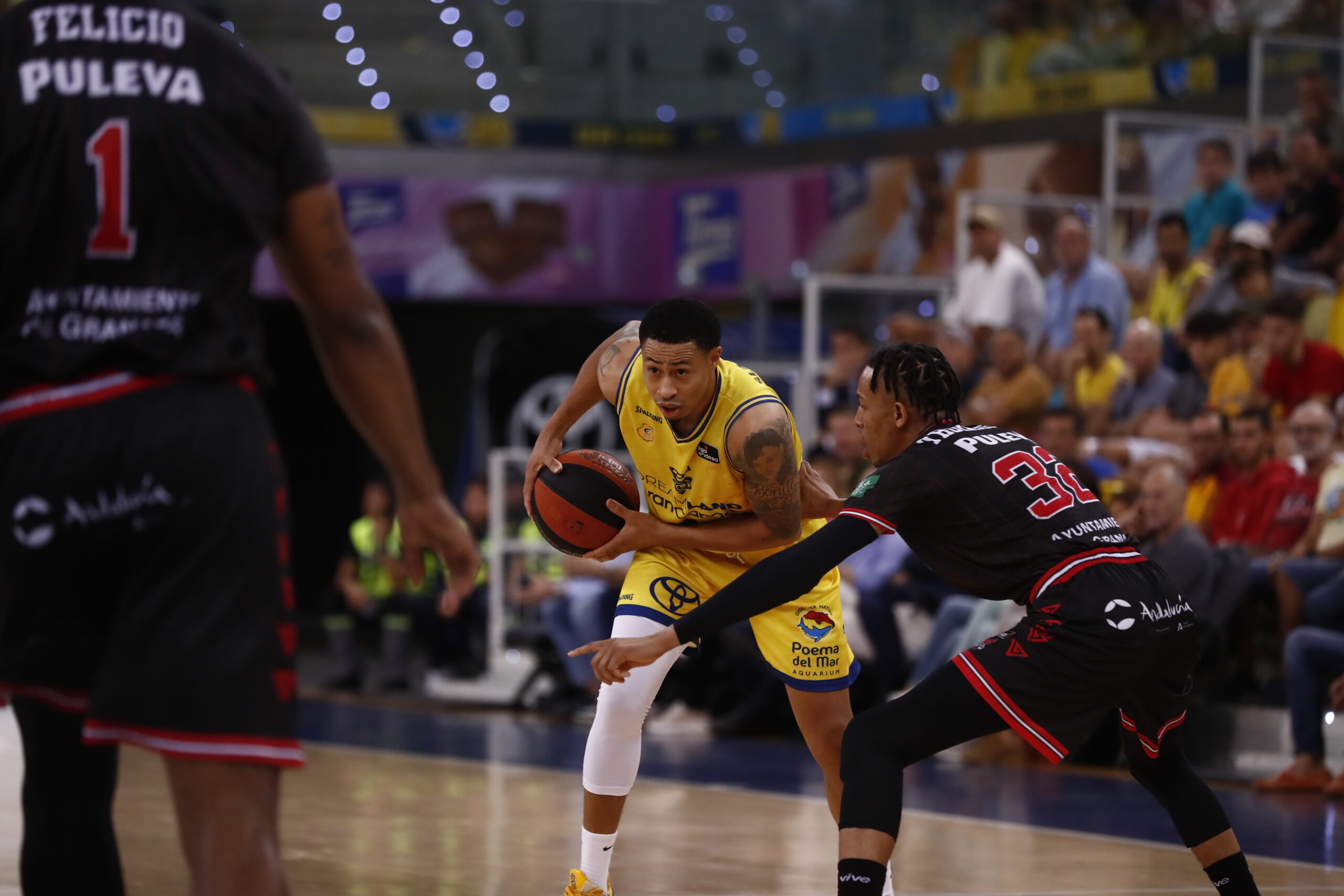 Jugador del Dreamland Gran Canaria driblando mientras es defendido por un rival.