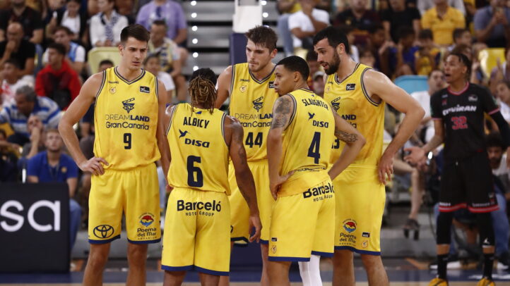 Jugadores del Gran Canaria en un tiempo muerto, discutiendo estrategias durante el derbi.