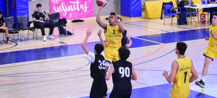 Jugador del CB Gran Canaria lanza a canasta mientras otros jugadores defienden.