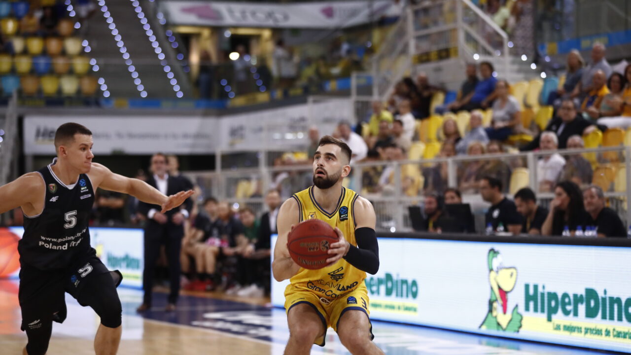 Jugadores durante un partido de baloncesto en el Gran Canaria Arena, uno con balón.