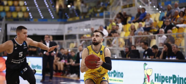 Jugadores durante un partido de baloncesto en el Gran Canaria Arena, uno con balón.