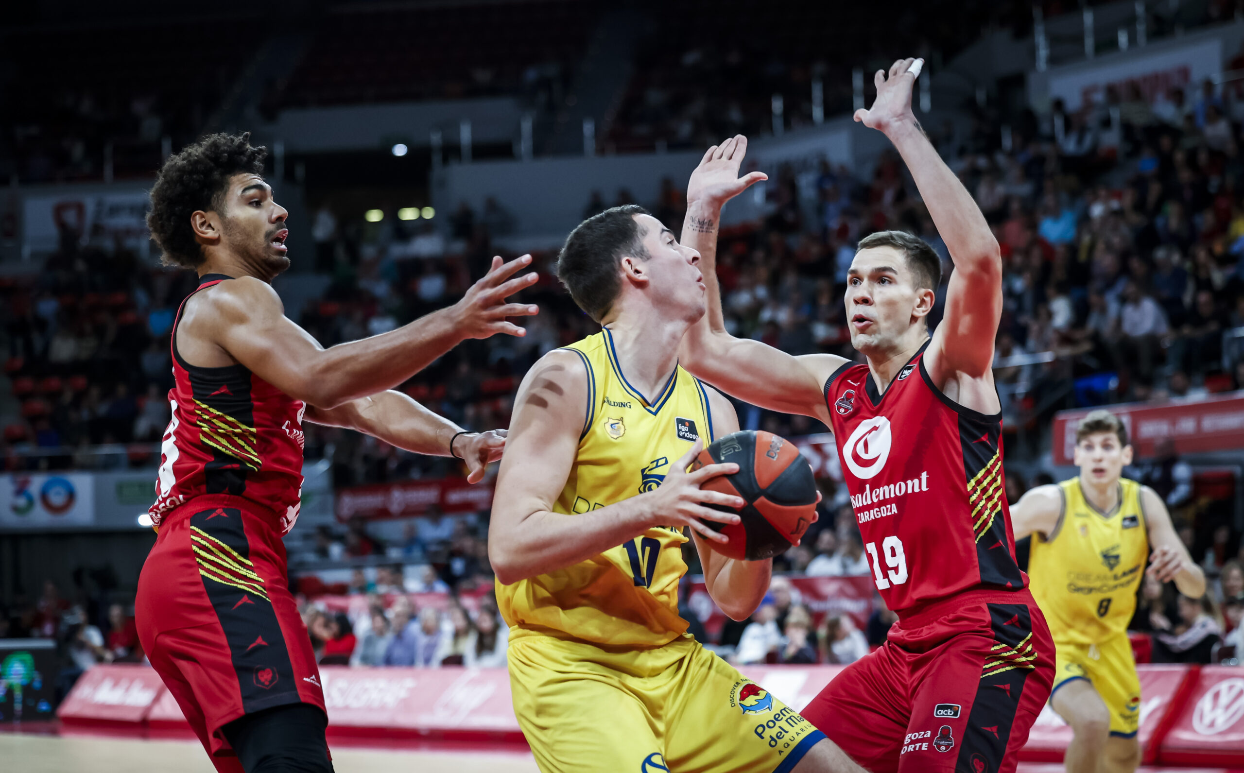 Acción intensa de un partido de baloncesto entre el Gran Canaria y Zaragoza.