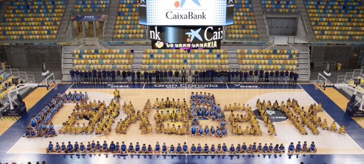 Jugadores y entrenadores del Club Baloncesto Gran Canaria formando el logo de CaixaBank en la cancha.