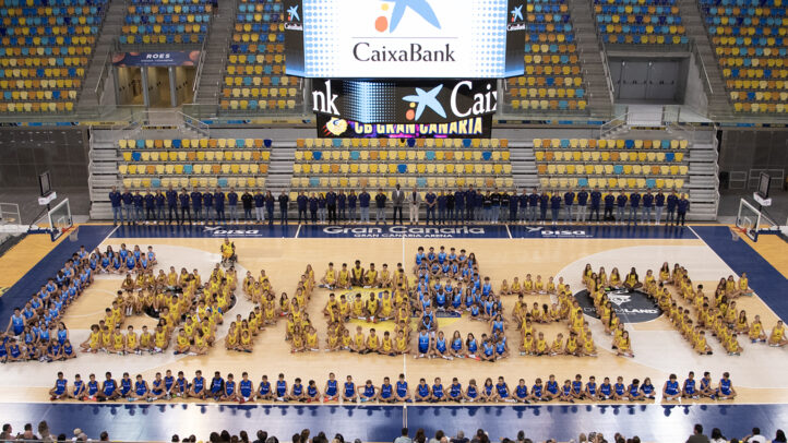 Jugadores y entrenadores del Club Baloncesto Gran Canaria formando el logo de CaixaBank en la cancha.
