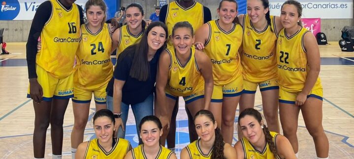 Equipo de baloncesto femenino posando juntos en la cancha tras un triunfo.