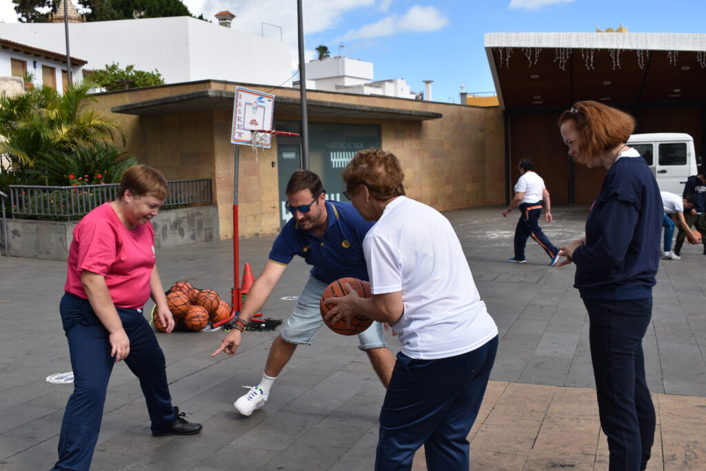 Actividad de baloncesto con varias personas en un espacio al aire libre.