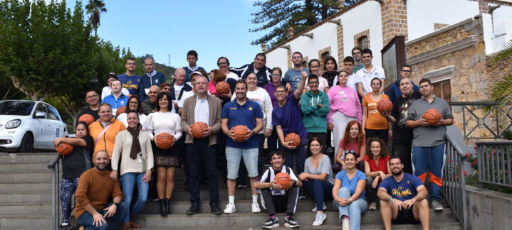Grupo diverso de personas sosteniendo balones de baloncesto en un evento en Teror.