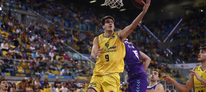 Jugador del Dreamland Gran Canaria intenta encestar mientras los rivales defienden.
