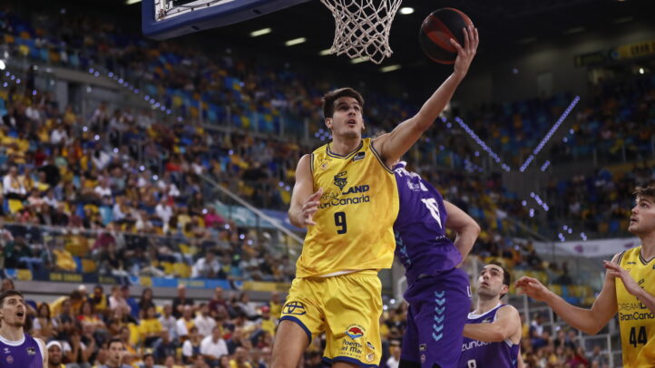 Jugador del Dreamland Gran Canaria intenta encestar mientras los rivales defienden.