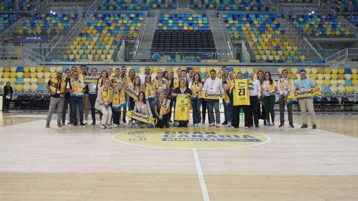 Grupo de personas posando en la cancha con bufandas y camisetas del CB Gran Canaria.