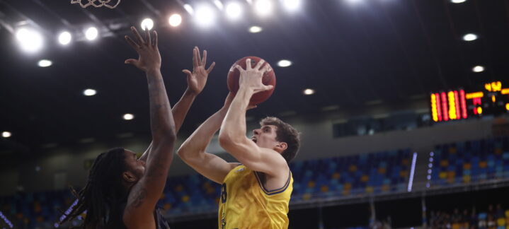 Jugador del Dreamland Gran Canaria lanza a canasta mientras es defendido por un rival.
