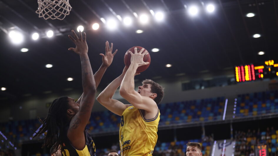 Jugador del Dreamland Gran Canaria lanza a canasta mientras es defendido por un rival.