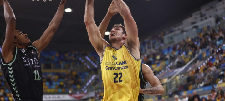 Jugadores en acción durante un partido de baloncesto, luchando por el aro.