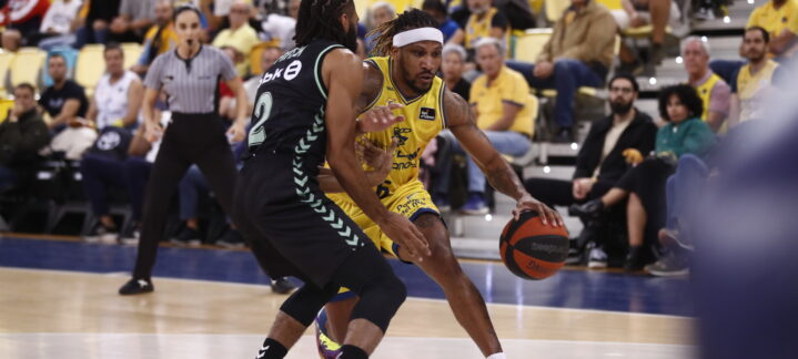 Jugador del Dreamland Gran Canaria driblando ante un rival en un partido de baloncesto.