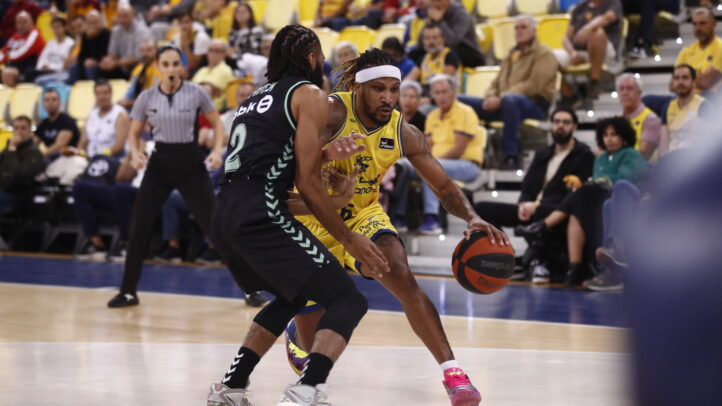 Jugador del Dreamland Gran Canaria driblando ante un rival en un partido de baloncesto.