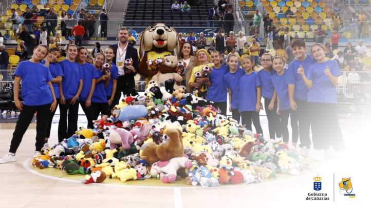 Grupo de jóvenes con peluches en una pista, celebrando la recogida solidaria.