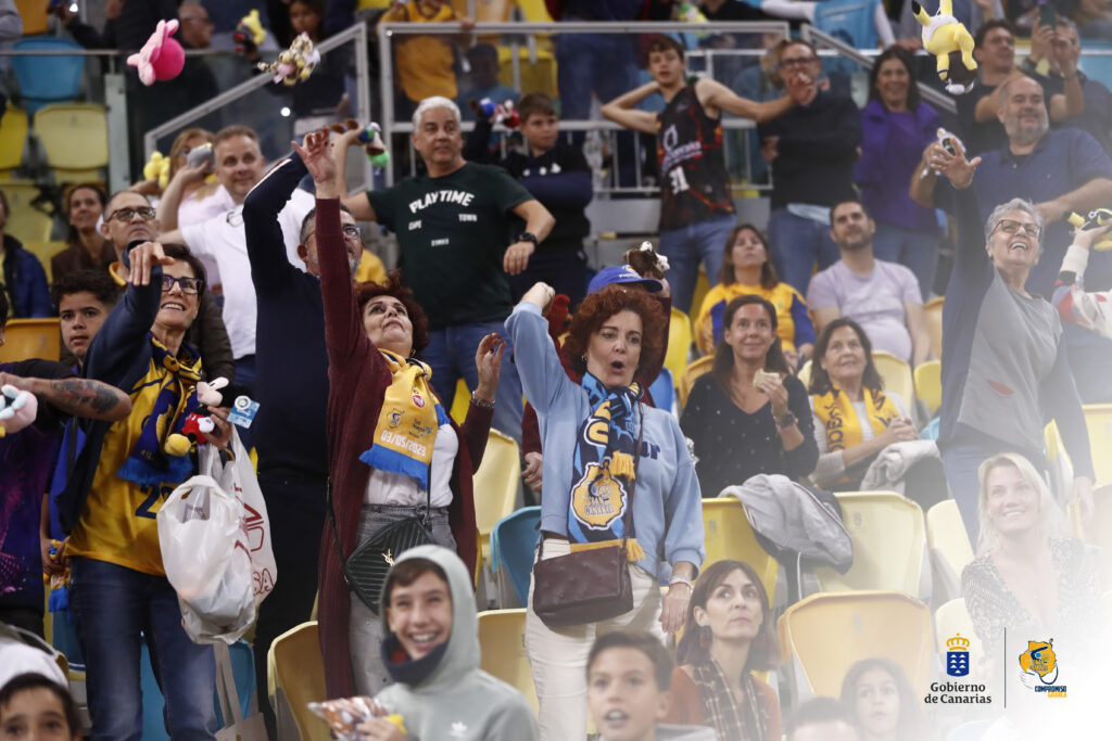 Aficionados lanzando peluches en un evento solidario del Club Baloncesto Gran Canaria.