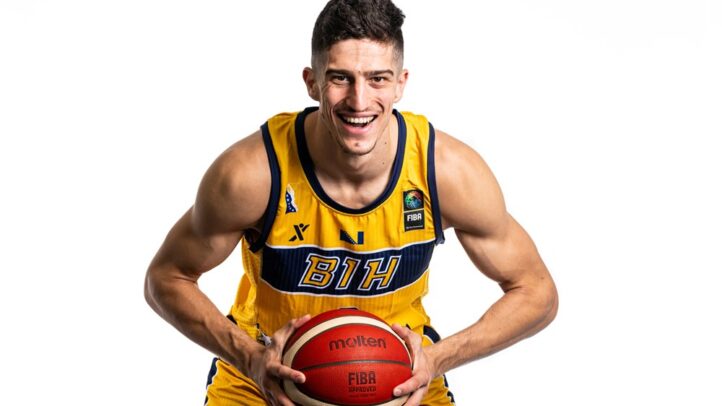 Jugador sonriente del Dreamland Gran Canaria con balón de baloncesto en manos.