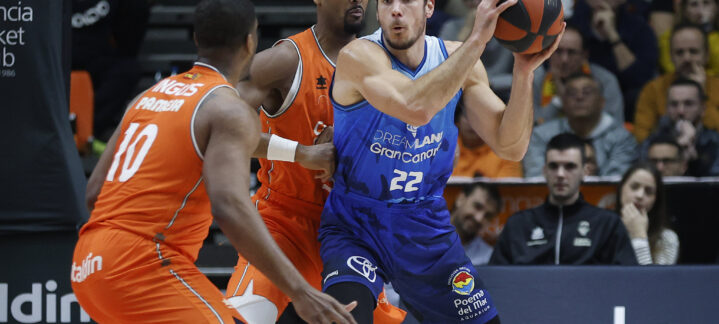 Jugador del Gran Canaria en acción, driblando con el balón ante defensores rivales.