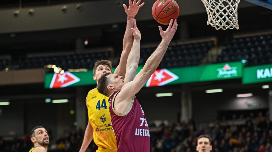 Jugadores compiten por el rebote durante un partido de baloncesto en Panevezys.