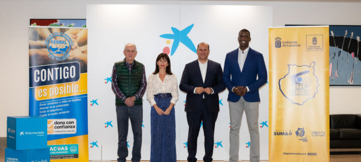 Cuatro personas posan en un evento del Club Baloncesto Gran Canaria junto a carteles de patrocinadores.
