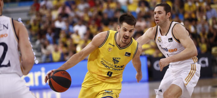 rival del Dreamland Gran Canaria en el Playoff Liga Endesa 2024",Jugador del Dreamland Gran Canaria avanza con el balón durante el playoff ante el Real Madrid.