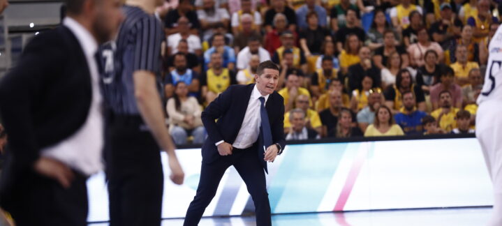 Jaka Lakovic dirigiendo a su equipo en un partido, con aficionados al fondo.
