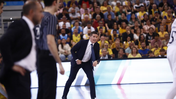 Jaka Lakovic dirigiendo a su equipo en un partido, con aficionados al fondo.