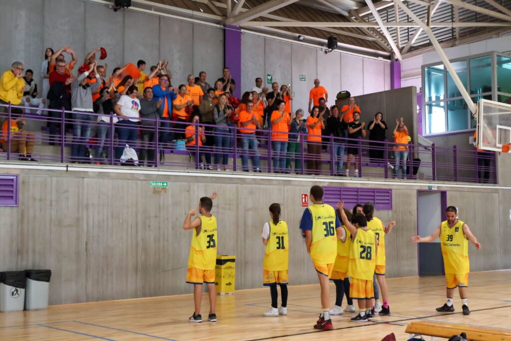 Aficionados animan a los jugadores durante un partido de baloncesto inclusivo.