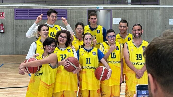 Grupo de jóvenes sonrientes con balones de baloncesto, vistiendo camisetas amarillas del Club.