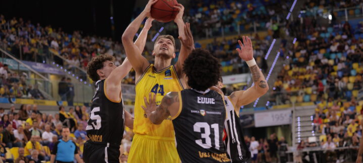 Jugador del Gran Canaria en acción, intentando encestar frente a los defensores rivales.