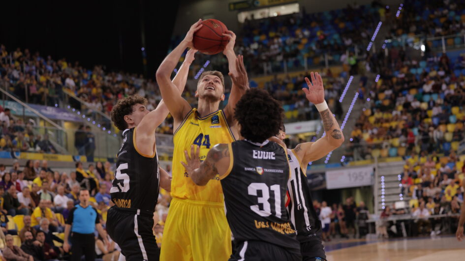 Jugador del Gran Canaria en acción, intentando encestar frente a los defensores rivales.
