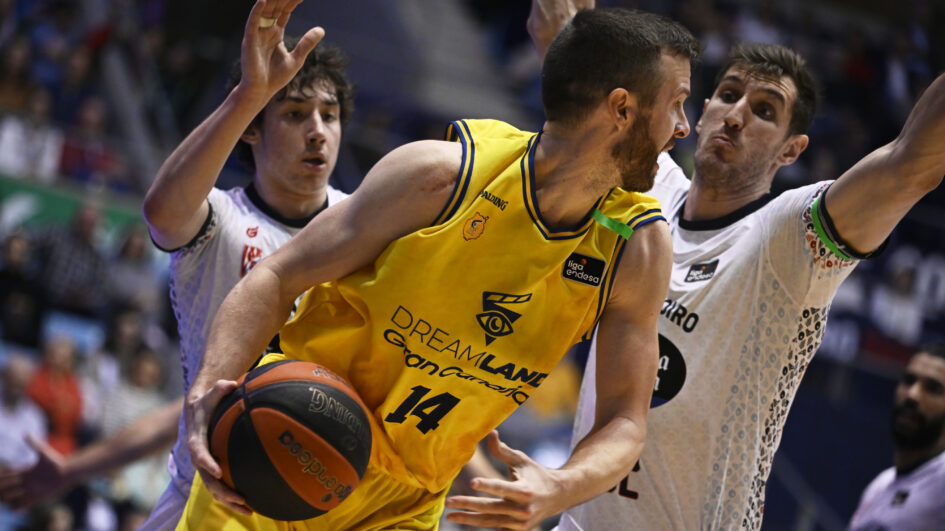 Jugador del Dreamland Gran Canaria intenta driblar entre defensores en un partido.