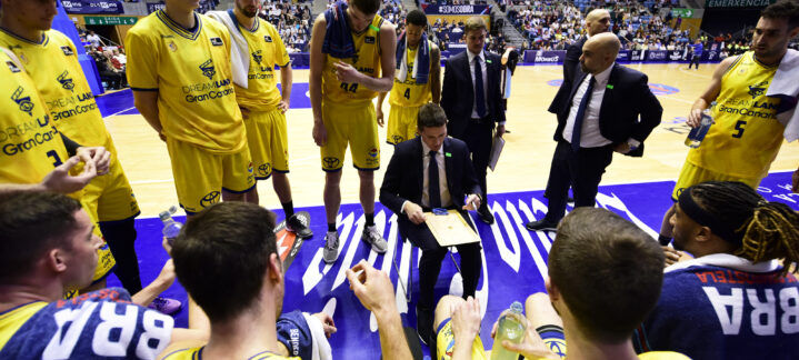 Entrenador del CB Gran Canaria dando instrucciones a los jugadores durante un tiempo muerto.