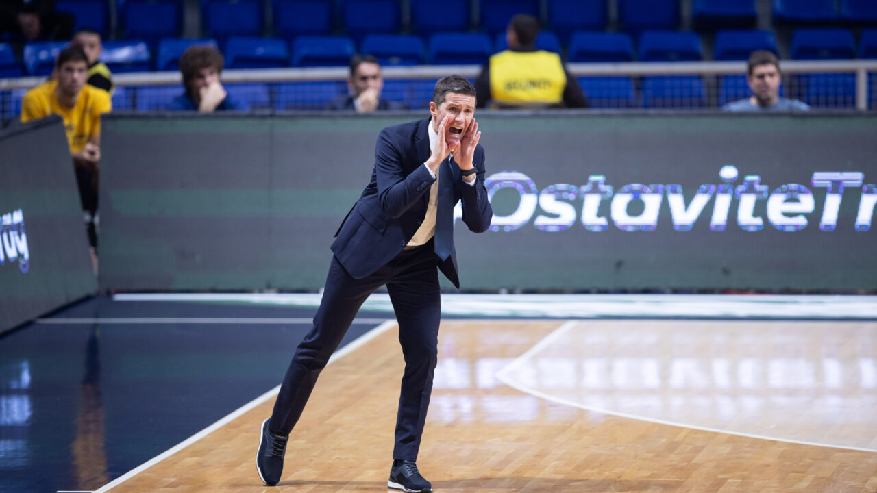 Entrenador animando a su equipo durante un partido de baloncesto en la cancha.